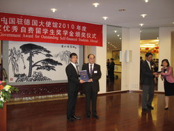 Xiaolong Ma erhält aus den Händen des chinesischen Botschafters, Hongbo Wu, den mit 5000 Dollar prämierten Wissenschaftspreis.