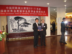 Gang Qui erhält aus den Händen des chinesischen Botschafters, Hongbo Wu, den mit 5000 Dollar prämierten Wissenschaftspreis.