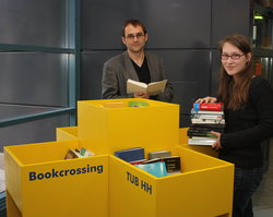 Sandy Willert und Detlev Bieler beim Bestücken des Bookcrossing-Regals.