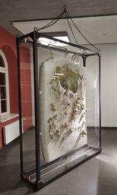 "Justus Brutkasten" von Nathan Egel hängt mit einem Gewicht von 300 Kilogramm in einem Schaukasten.