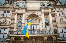 Die Flagge der Ukraine über dem Eingang des Rathauses: Im Herzen der Stadt setzt Hamburg damit ein deutliches Zeichen der Solidarität mit der Ukraine.